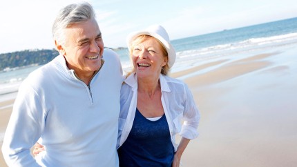 Sofortrente: Älteres Paar am Strand genießt seine Rente dank einer guten Rentenversicherung.